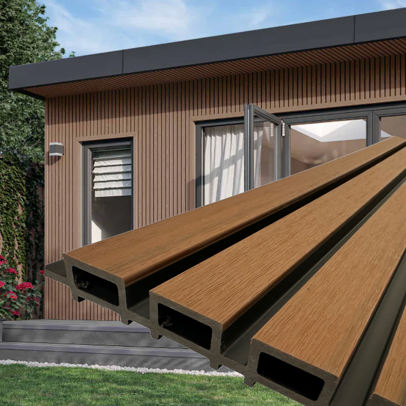 Composite decking boards in the foreground with a modern wooden house and open glass doors in the background.